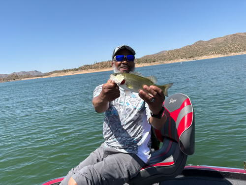 Fisherman with striped bass on boat