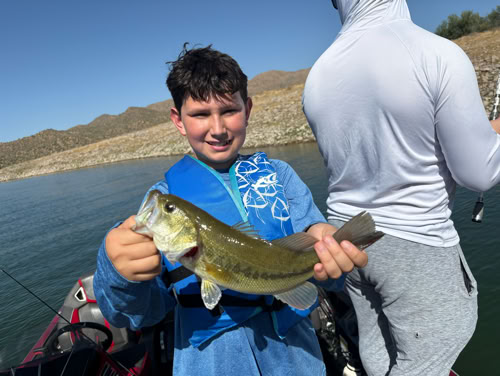 Boy with fish on fishing boat
